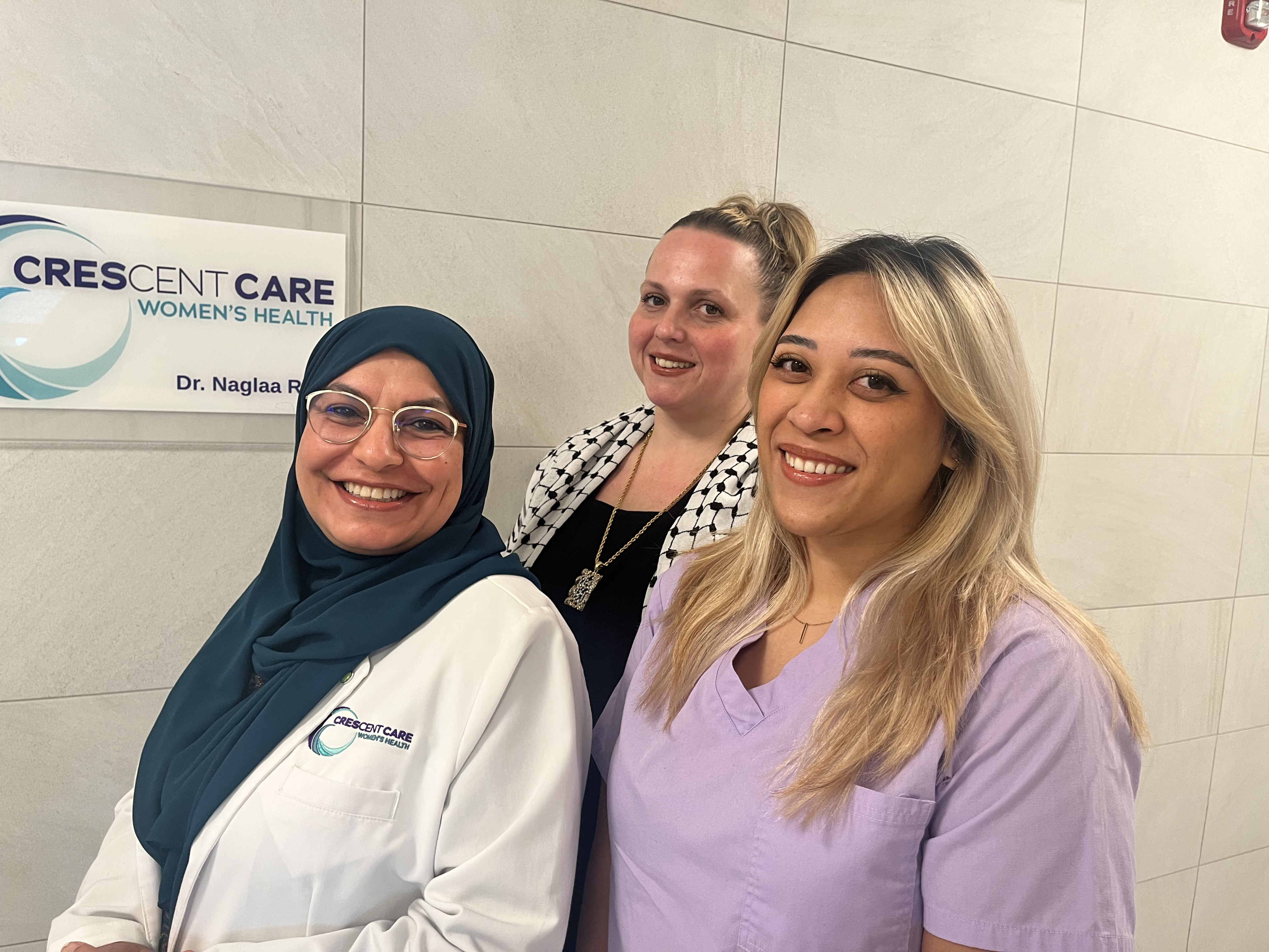 Three employees of CCWH smiling in front of CCWH office